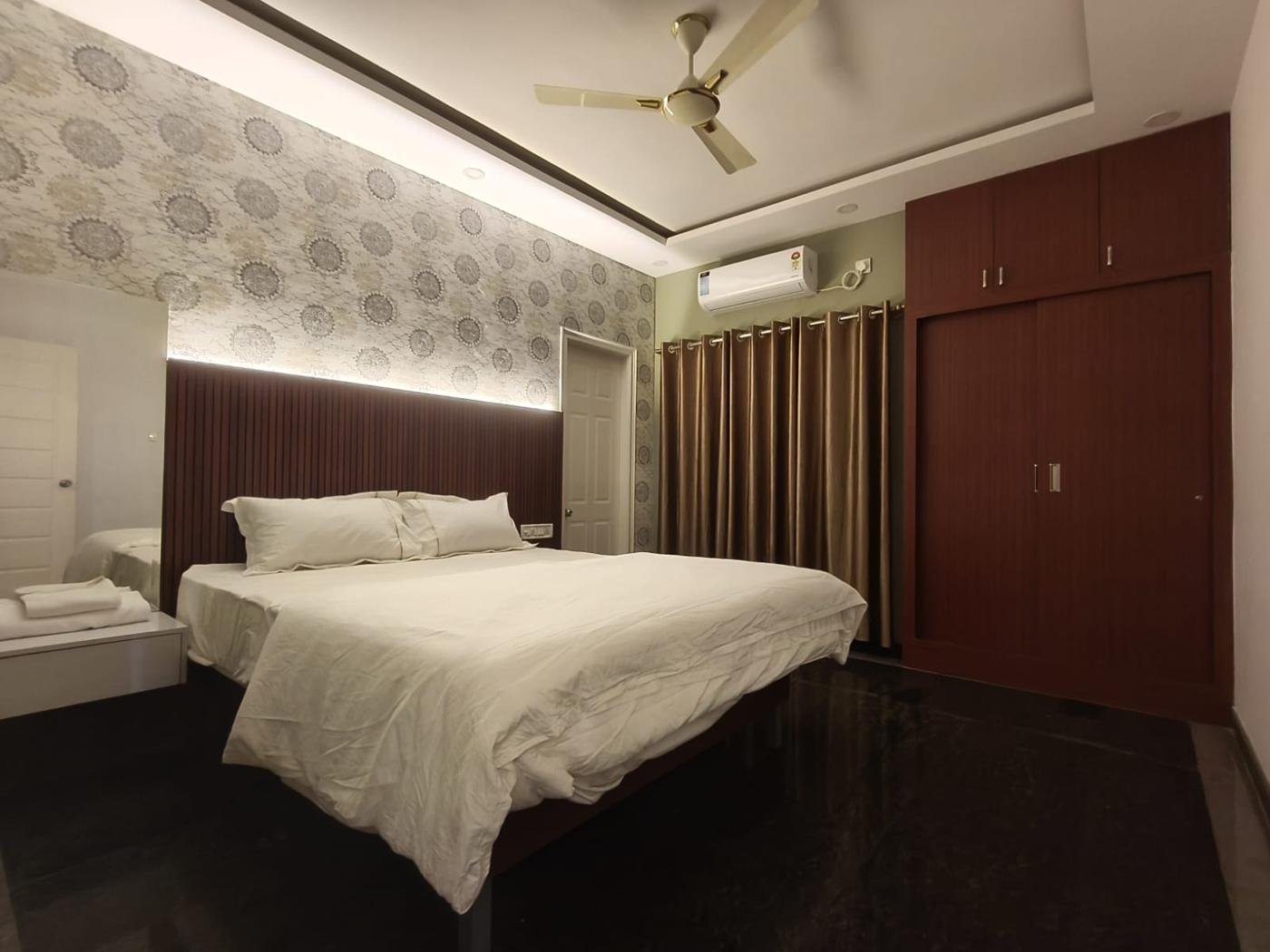 Bedroom with lit headboard panel and air conditioner
